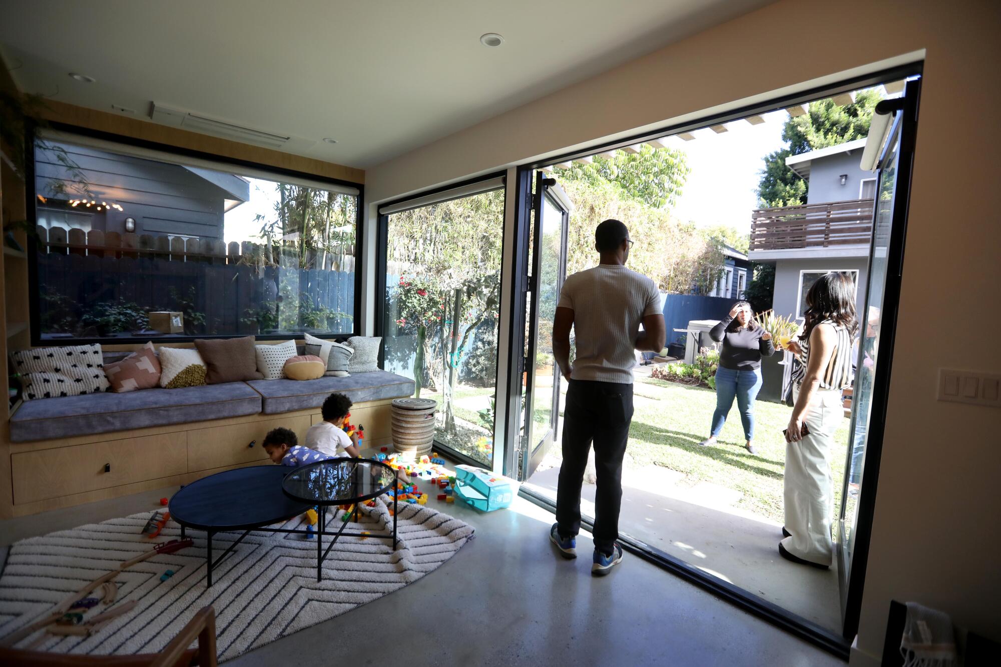 Dr. Pascal Dabel and his wife, Marina, right, talk with architect Susan Nwankpa Gillespie, center, inside an ADU.