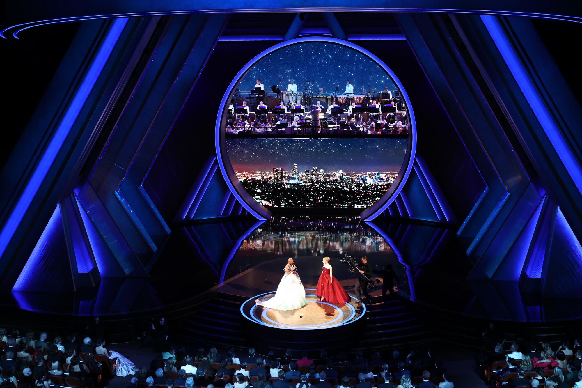 Two women in gowns on a stage.