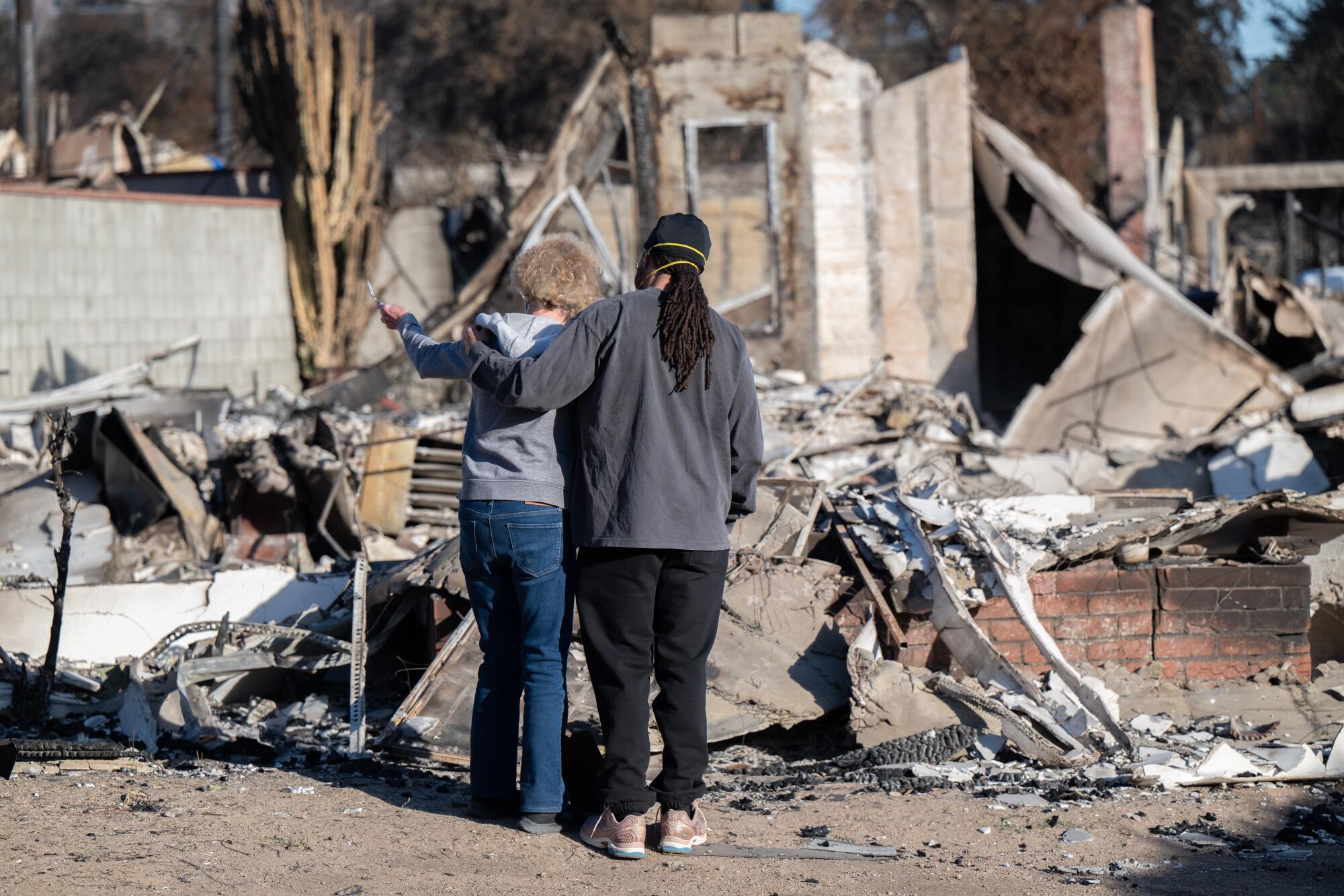 A mother and son look at their home.