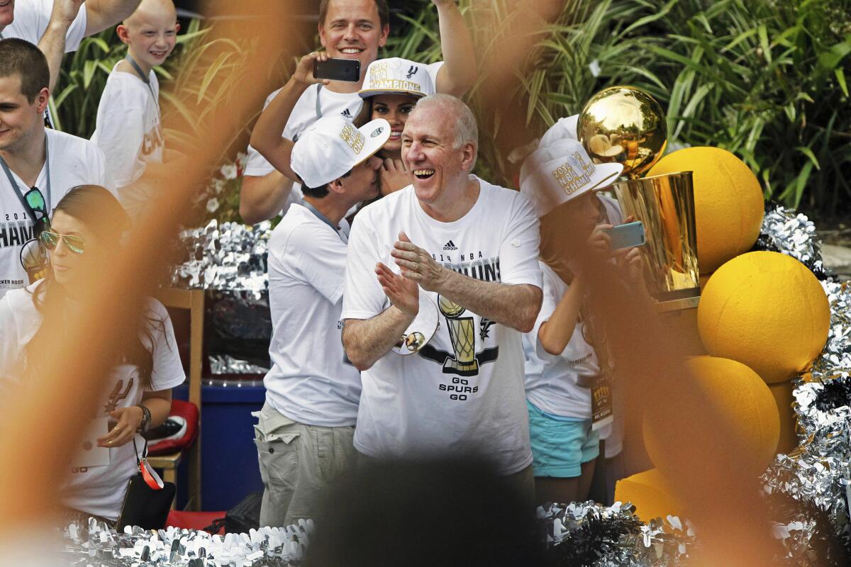 San Antonio Spurs coach Gregg Popovich, center, claps during the team's championship parade in June 2014.