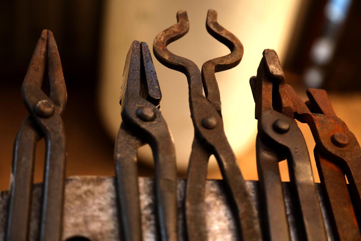 A variety of metal tongs in a knife maker's studio