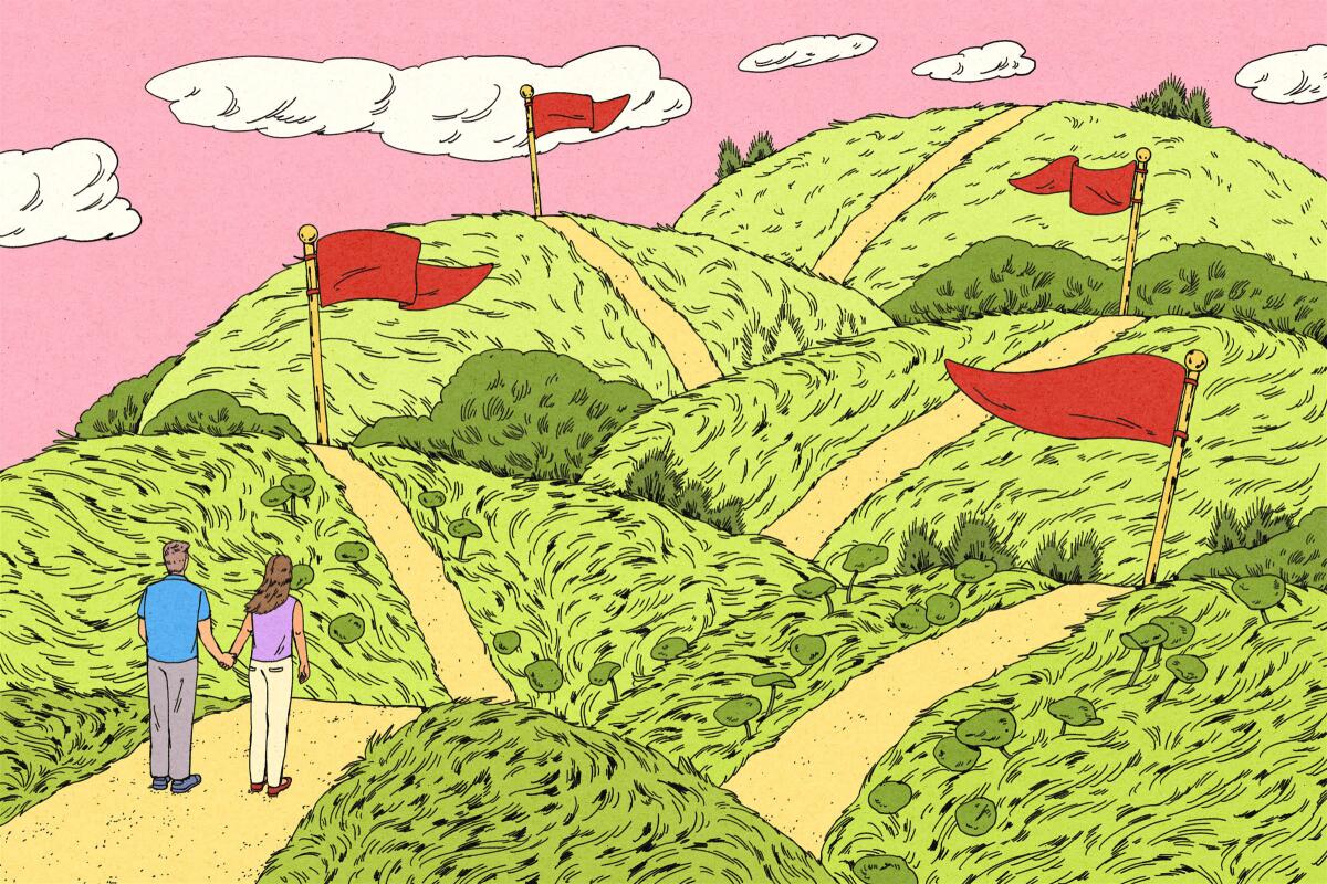 Two people holding hands look at hills with red flags dotting the path.