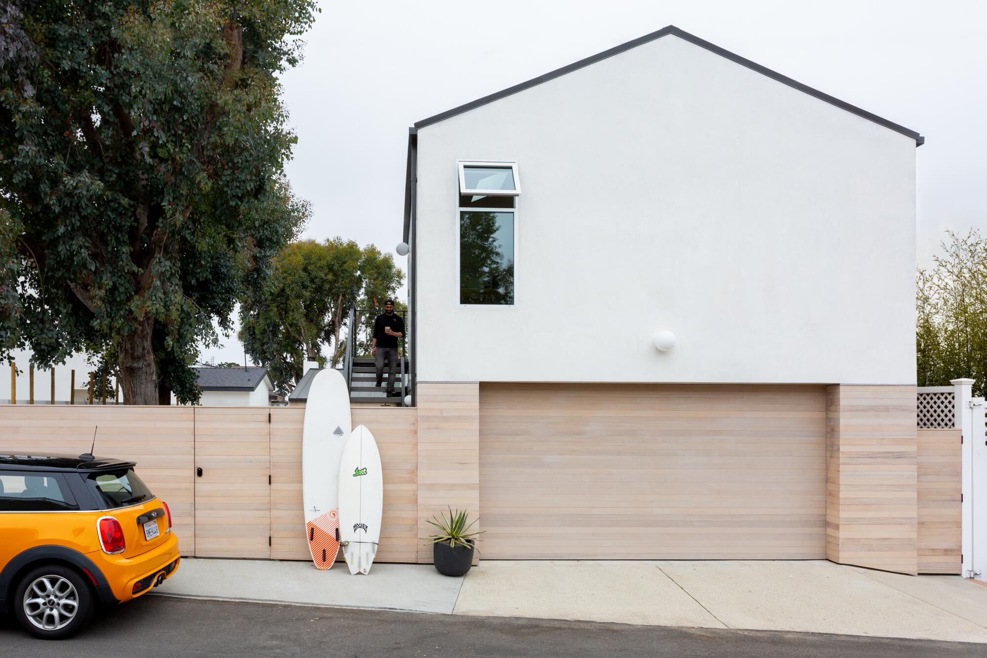 A modern white ADU seen from an alley.