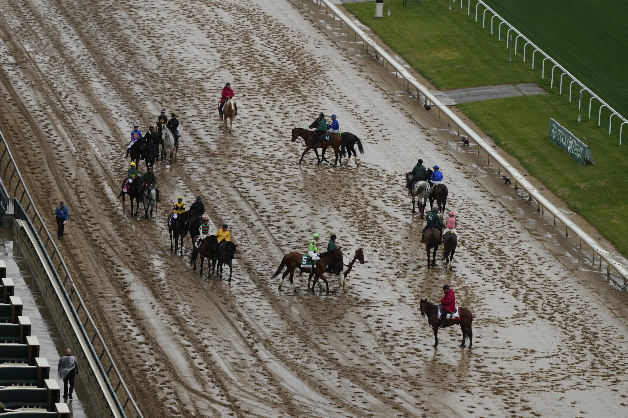 Horses prepare for a race on a muddy track at Churchill Downs on Saturday.