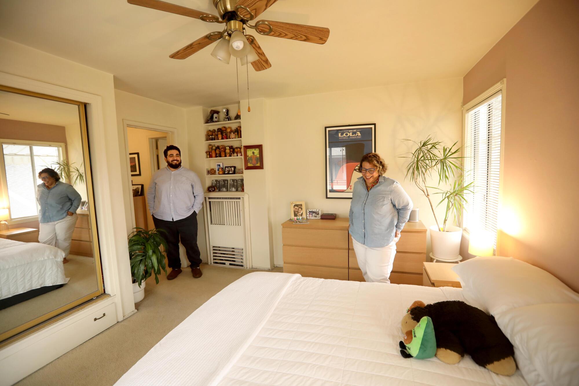 Abraham and Cecilia Beltran stand in the bedroom of their apartment