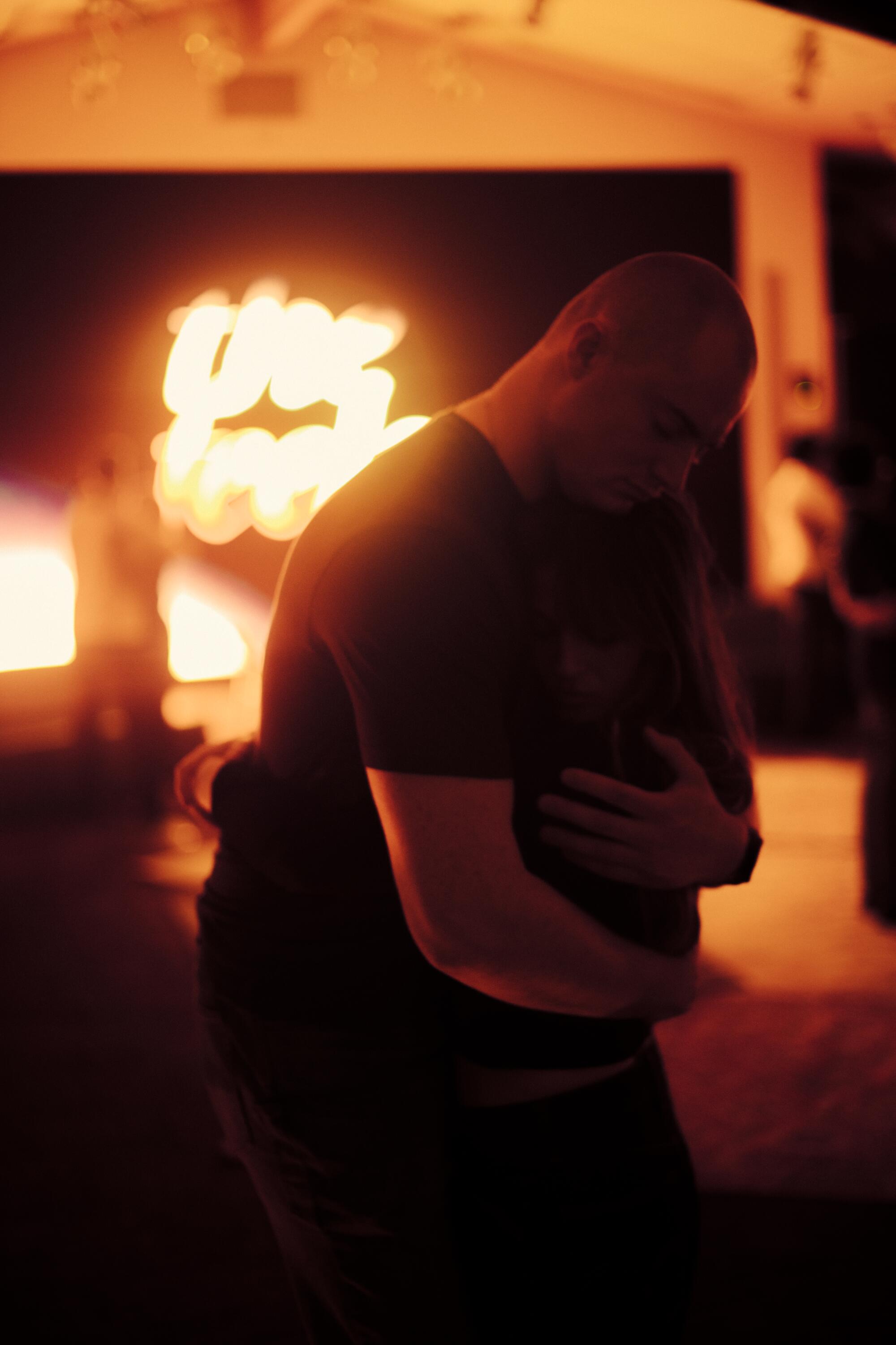 A man and a woman hug.