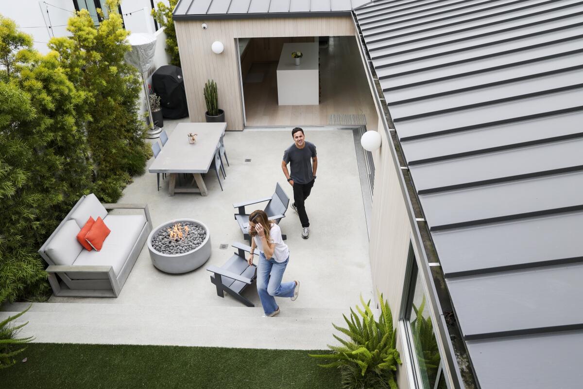 Cailin and Paul Goncalves walk through their backyard