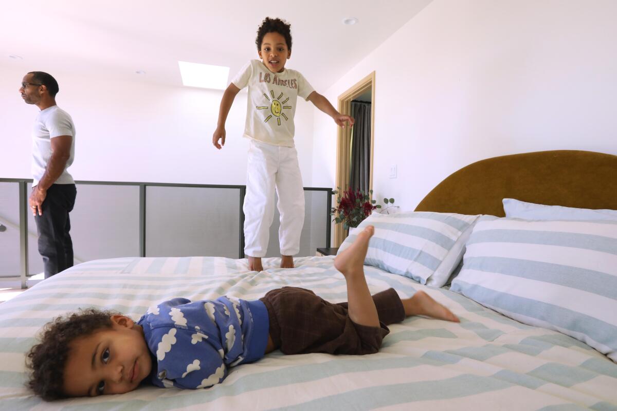 Lucien Dabel, 3, foreground, and Lorenzo, 7, play on the bed.